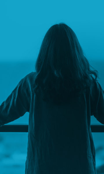 Woman enjoying the tranquil ocean view from her balcony