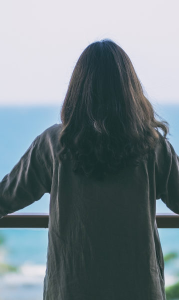 Woman enjoying the tranquil ocean view from her balcony