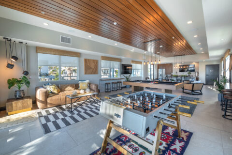 Clubroom with foosball table, pool table, bar seating and plush seating, designer lighting and a kitchenette