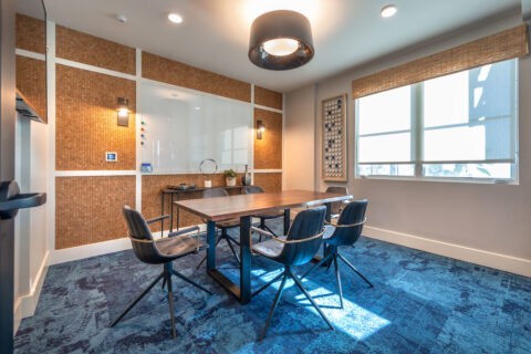 Conference room with table and chairs, large window and a whiteboard