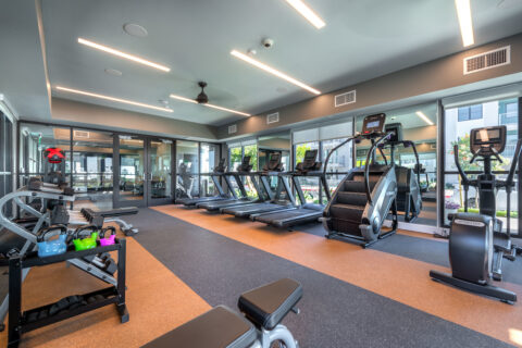 Fitness center with ceiling fans, cardio equipment including treadmills, stair master and elliptical machines and strength training equipment including free weights