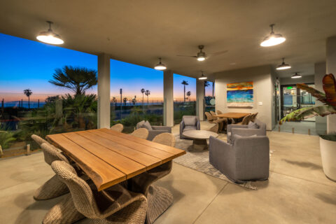 Evening shot of covered outdoor seating with tables and chairs, overlooking the ocean